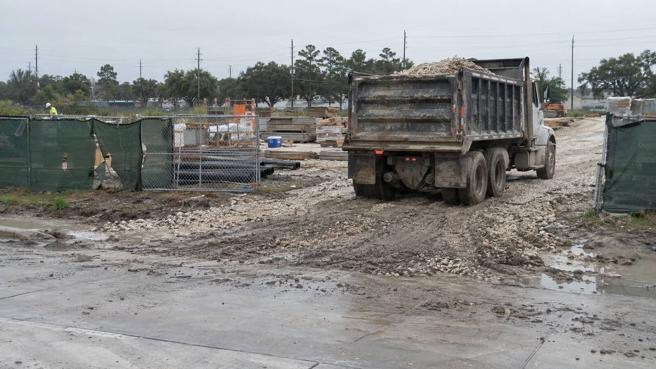 Loaded dump truck leaving a crushed rock construction entrance on a Houston jobsite